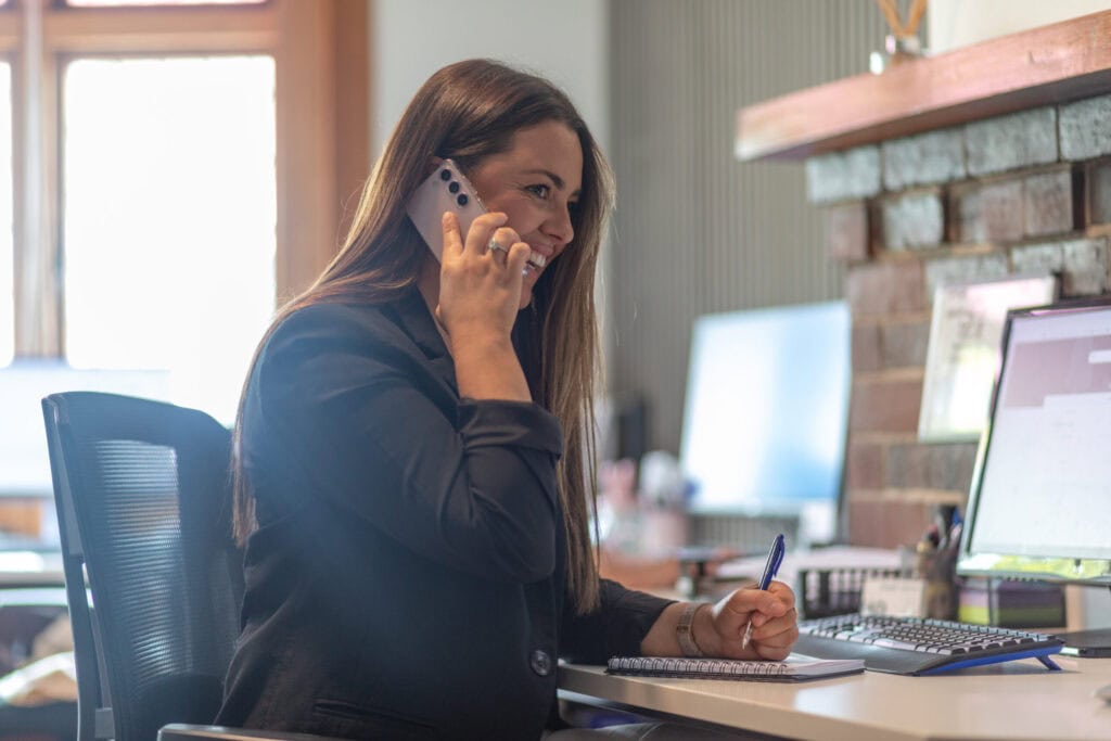 Happy glasshouse team member on the phone